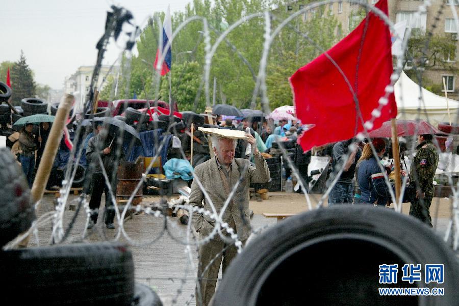  5月8日，在乌克兰东部城市顿涅茨克，一名男子在州政府大楼前。乌克兰东部亲俄派8日宣布，他们仍将按计划于11日就今后自身地位举行公民投票，乌克兰全国和解前景仍不乐观。新华社发（亚历山大·叶尔莫琴科摄） 