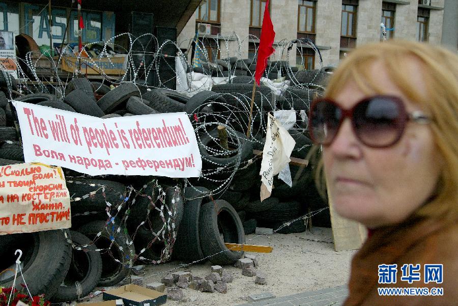 　 5月8日，在乌克兰东部城市顿涅茨克，一名女子站在州政府大楼前的路障前。乌克兰东部亲俄派8日宣布，他们仍将按计划于11日就今后自身地位举行公民投票，乌克兰全国和解前景仍不乐观。新华社发（亚历山大·叶尔莫琴科摄） 
