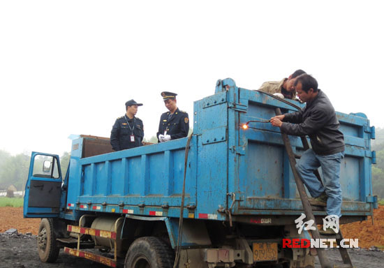 工作人员现场切割拆解非法改装超载车