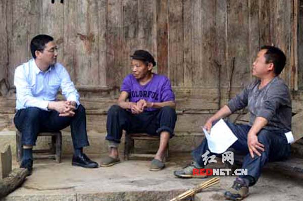 永顺县委常委、纪委书记田源[左]与对子帮扶对象余泽选[中]交谈。