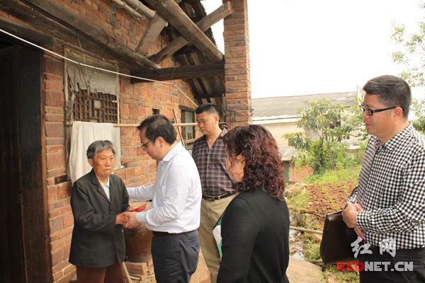 邵阳市国税局局长李石道（左二）率队慰问来到磨石社区特困居民黄雪莲。