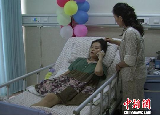 病床上的沂蔓接听男友打来的问候电话，妈妈在身旁陪护。 王帅 摄