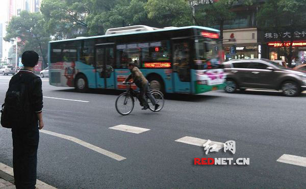 中心广场，一位骑单车的市民横穿马路