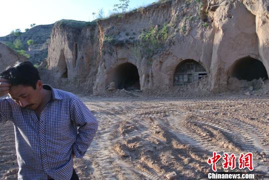 王家沟村民站在自家窑洞前。　李新锁摄