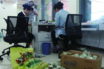 抬着6袋钱存银行 8万元零钱20多人8小时点清