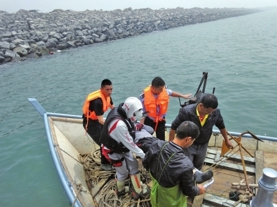 民警、渔民合力将伤者抬上岸