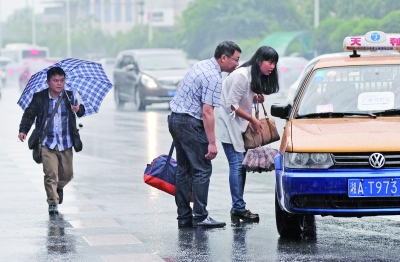 5月21日下午，长沙市五一大道，细雨纷纷，许多市民站在路边拦的士。记者　李健　摄