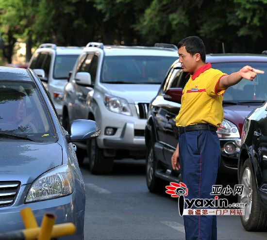 5月29日19时,红山路加油站的工作人员,正在进口维持车辆秩序。陈峰 摄
