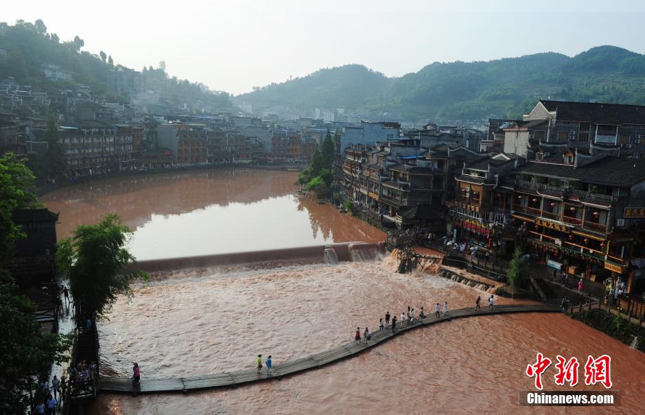 　　6月1日，游客正在与暴雨之后的凤凰古城一河堤合影。当日下午，暴雨突袭湖南凤凰古城，一小时降水量达42毫米，导致城内的沱江河水位猛涨。中新社发 杨华峰 摄 来源：中新网
