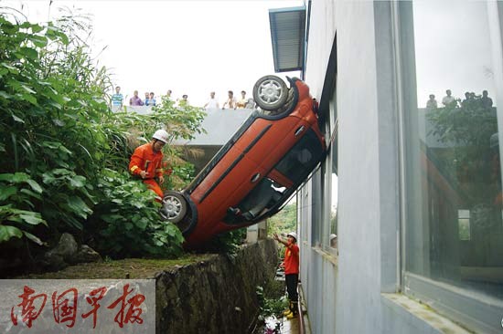 小轿车倒车翻下路边深沟。都春雷 摄