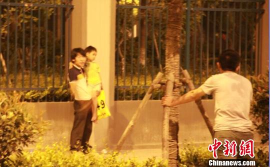 持刀男子始终抓着4岁儿童的手。 袁宝德 摄