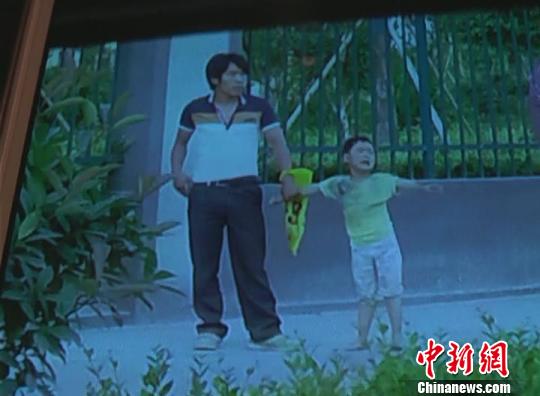 持刀男子始终抓着4岁儿童的手。 袁宝德 摄