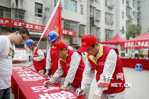 岳阳供电公司员工在横幅上承诺签名。