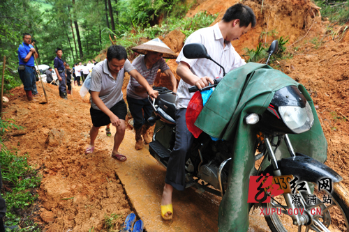 大华乡红岩村村民抢通公路后，一辆摩托从中通过