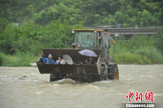 图为：被困的3名村民被铲车营救。　任益摄