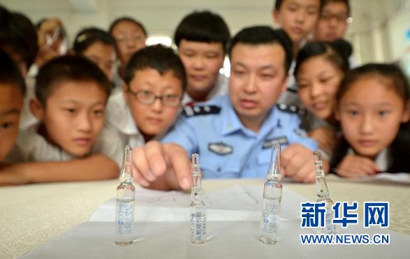 6月24日,河北省邯郸市公安局禁毒支队民警给渚河路小学的学生们介绍毒品带来的危害。世界禁毒日到来之际,各地纷纷开展禁毒宣传进校园活动,让孩子们认识毒品、远离毒品。6月26日是国际禁毒日,今年的主题是“珍惜美好青春,远离合成毒品,拒绝毒品,健康人生”。 新华社发(郝群英 摄)
