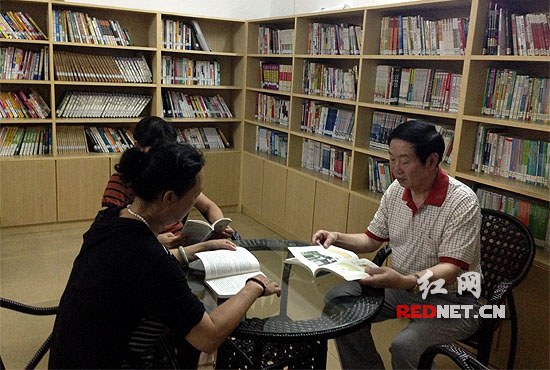 图:湖南省永兴县滨河路社区,几名老人正在该社区的免费读书吧看书。