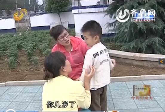 记者问小张的儿子几岁了，从小没有父亲的孩子并不说话，只是依偎在母亲身边（视频截图）
