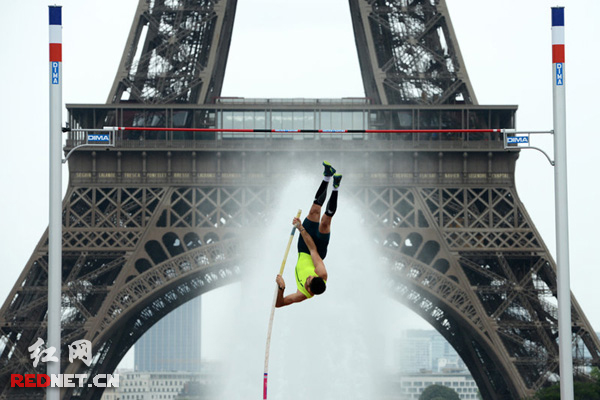 　当地时间2014年6月28日，法国男子撑杆跳世界纪录保持者拉维莱涅在巴黎埃菲尔铁塔前举行表演赛，拉维莱涅的兄弟Valentin同场竞技。图片来源：CFP