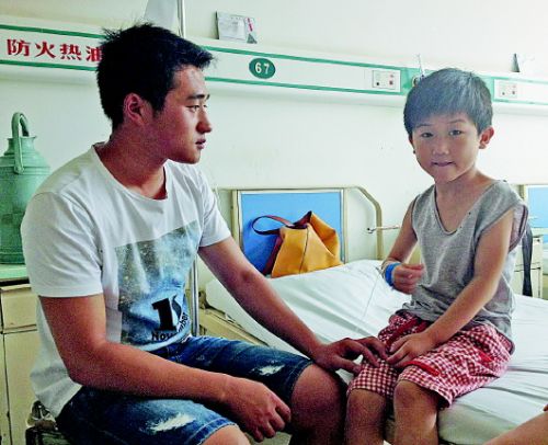 孔令武到医院看望被救的小旭斌。本报记者孟杰摄 