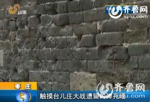 很多子弹打在同一个地方，造成墙面的蜂窝状弹痕。（视频截图）