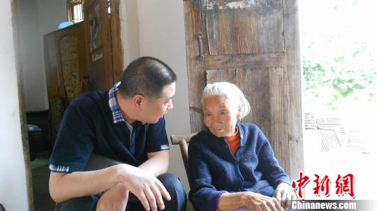 幸存者杨学英老人向记者一行讲述，村民惨遭日军屠杀。 刘文泉 摄