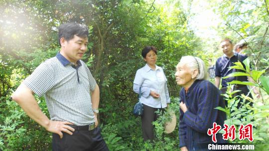 幸存者杨学英老人向记者一行讲述，村民惨遭日军屠杀。 刘文泉 摄