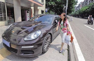 蔡晓琴和她的保时捷轿跑车。本版图/重庆晨报记者 杨新宇 摄