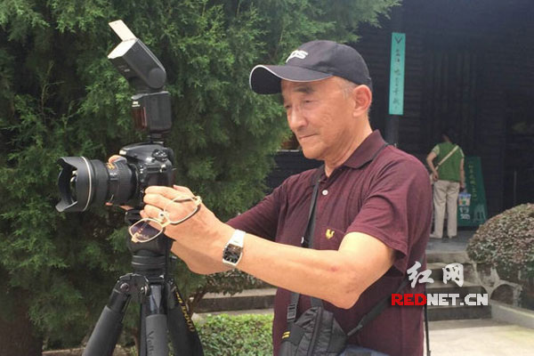 摄影发烧友毛桂荣在为团友拍照