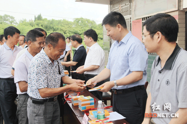（7月3日，衡阳县领导在岘山镇星光村举行《减负惠农政策宣传手册》首发仪式上给村民发放手册。）