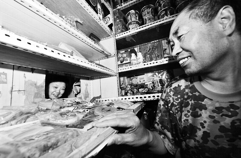不忙的时候，李军生会通过货架上的小窗跟妻子说说话
