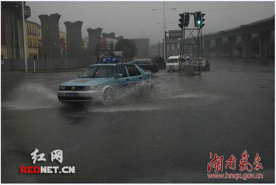  今晨长沙市芙蓉南路，暴雨中车辆驶过积水的路面 摄影：姚宏权