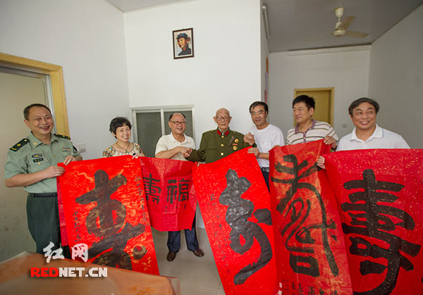 7月20日上午，湖南省直书画家协会几位书法家向老红军陈云忠[中]赠送书法作品。