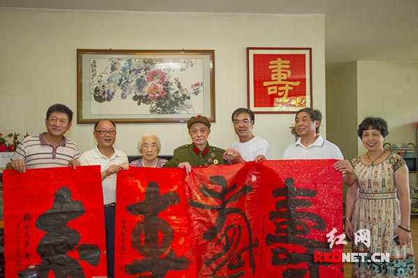 湖南省直书画家协会几位书法家向老红军张生荣[中]赠送书法作品。