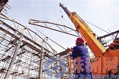 施工人员正在安装联合车库的首榀屋架。谭清云 摄