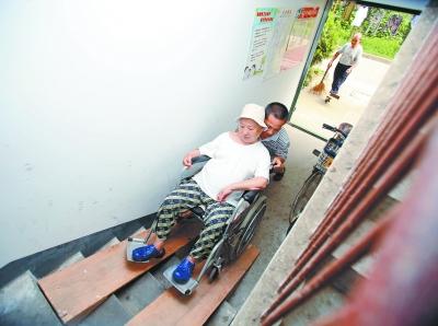 推着轮椅从斜坡板上上楼。