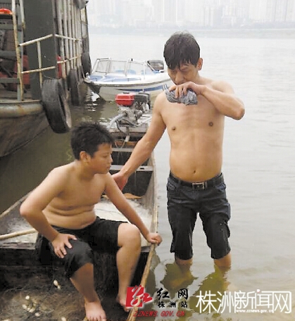 老人上岸时，根本站不起来，救援队员搀扶老人上岸。李汉桥/摄