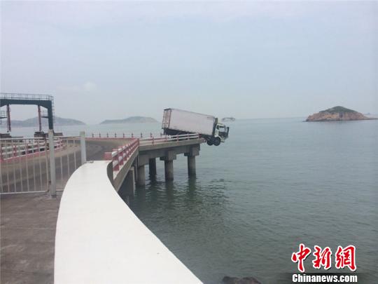 浙江嵊泗一货车冲出护栏车头凌空悬海因操作不当