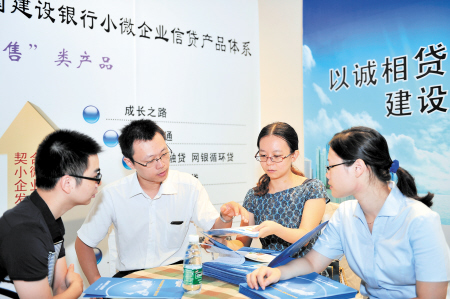 在金融服务节上,银行工作人员针对小微企业推介金融服务产品。(资料图片)