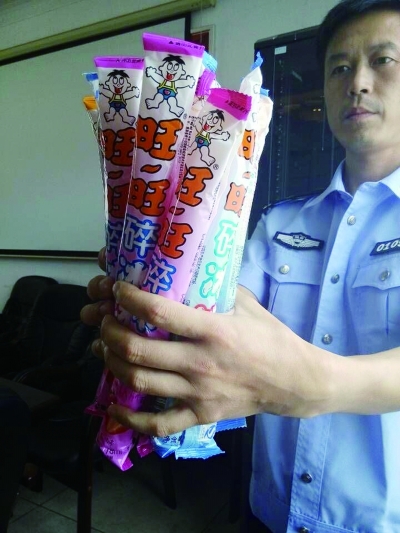 民警在展示收缴的假劣“旺旺碎冰冰”。 通讯员 供图