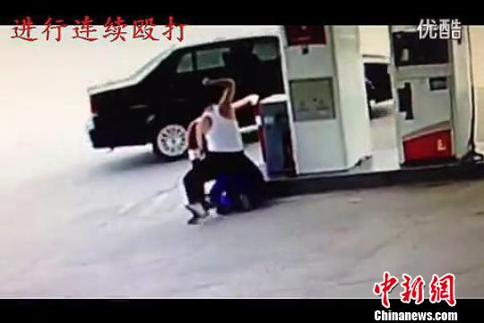该名男子正在对加油站工作人员殴打,图为网友上传的视频截图。 视频截图 摄