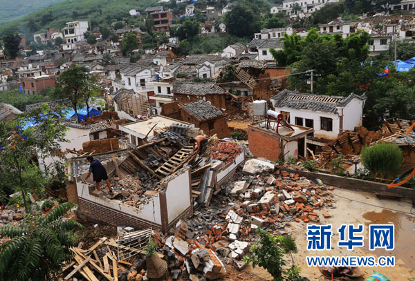 8月9日,在震中云南鲁甸龙头山镇骡马口,唐绍虎和父亲唐昌权在整理废墟。新华社记者邢广利摄