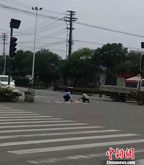 图为交警正在帮老人捡拾废品。 王生 摄