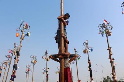 许多民众参加攀爬槟榔树争抢丰富奖品的传统庆祝活动。