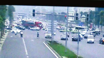 货车撞开警车后，强行左转向进城方向逃逸。（视频截图）