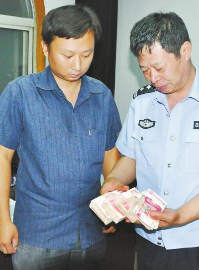 陈乾将捡到的5万元现金交给民警 警方供图