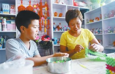 王艺科在帮妈妈编织手工艺品挣钱