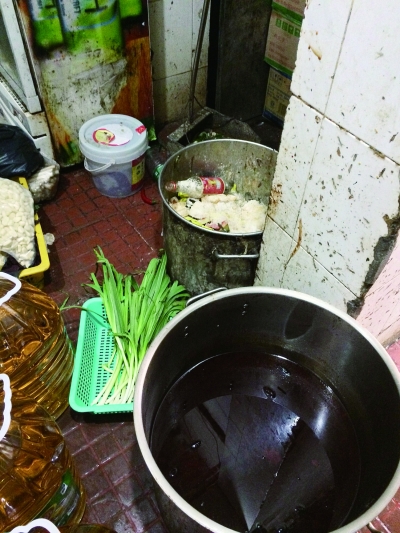 老梅园厨房外，店员正清洗餐具，污水横流(左图)。厨房储物间，一桶浸泡着食物的卤水正挨着一桶垃圾（右图）。本版图片均由记者  洪雷  摄