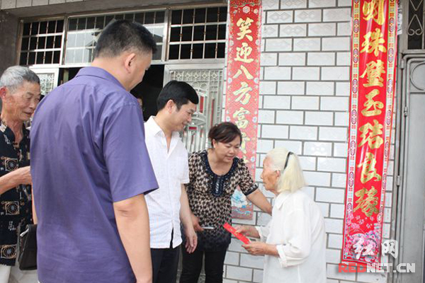 邵阳市国税局卿育龙副局长（右三）将慰问金送至97岁的困难群众手中。
