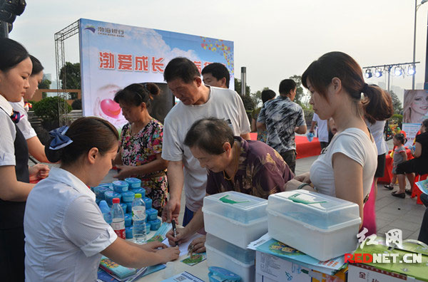 渤海银行的工作人员在活动现场为社区居民发放爱心医药包。